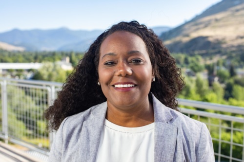 headshot of Terrill McFarland, a Black woman wearing a blue suit, with mountains in the background