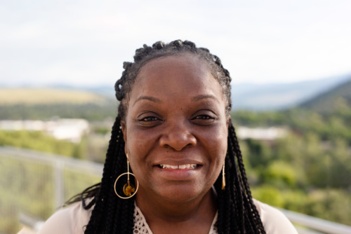 Headshot of Keisha Washington, a Black woman standing in front of scenic mountains