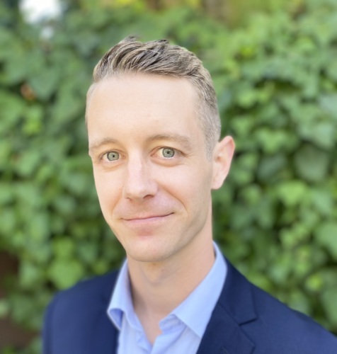 Headshot of Chance Smith, a 30 something white male wearing a blue suit.