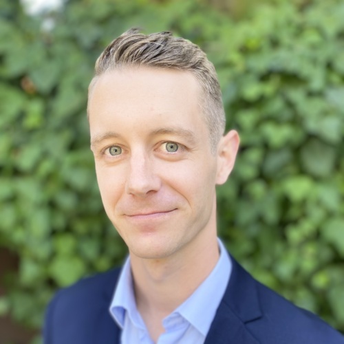 Headshot of Chance Smith, a 30 something white male wearing a blue suit.