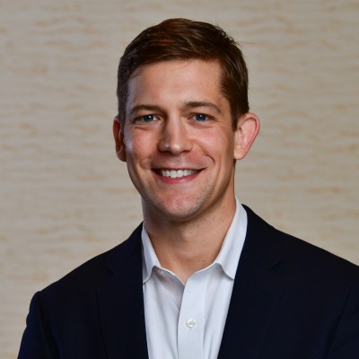 Headshot of Dan Biga, a white man in his 30s wearing a suit jacket